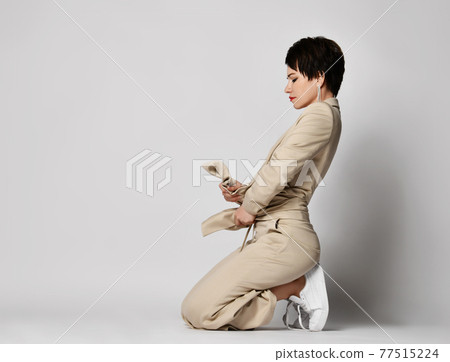 Adult woman in beige business casual pantsuit and 77515224