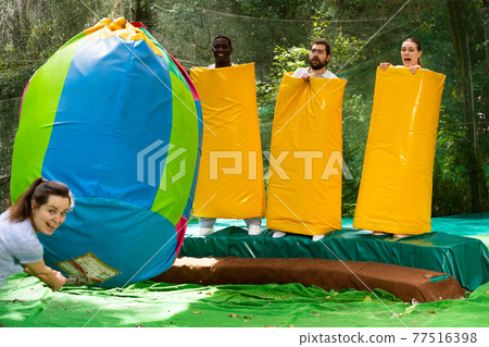 People as bowling pins in an amusement park on a summer sunny day People as bowling pins in an amusement park on a summer sunny day 77516398