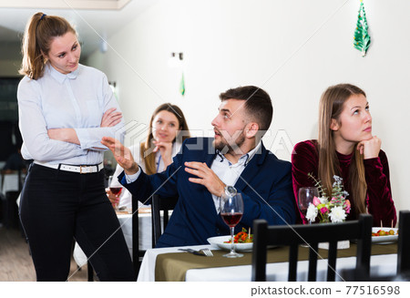 Woman is talking with couple in restaurante Woman is talking with couple in restaurante 77516598