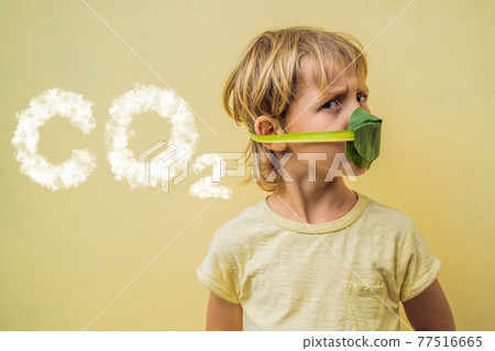 The child made himself a face mask from the leaves to protect himself from air pollution. CO2 lettering made of clouds. Sky with CO2 pollution, smog. Air purification for children concept. Trees 77516665