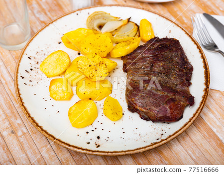 Image of a grilled beef steak and fried potatoes. 77516666