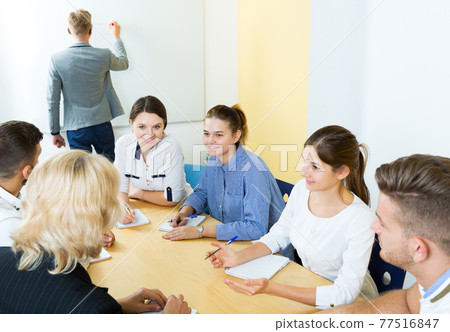 positive students working together in auditorium 77516847
