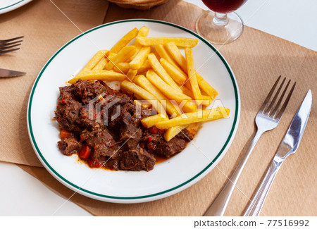 Wild boar in sauce with french fries 77516992