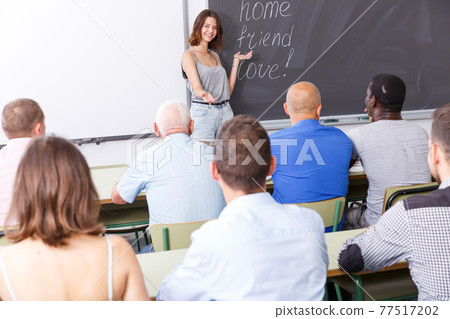 Young female lecturer talking to students 77517202