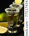 Shots of Mexican Gold Tequila with lime slices and salt. 77517434