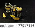Mexican Gold Tequila with lime slices and salt, top view 77517436