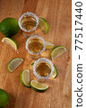 Mexican Gold Tequila with lime slices and salt, top view 77517440