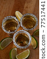 Mexican Gold Tequila with lime slices and salt, top view 77517441