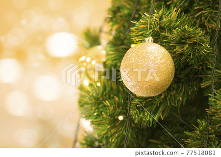 Christmas ball on tree. Closeup on Christmas tree decoration over festive background 77518081