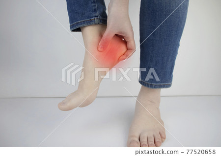 Woman suffering from heel pain. Inflammation or sprain of the tendon in the foot, heel spur, bursitis. The concept of diseases and pains in the leg 77520658