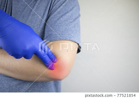 A man suffers from elbow pain. Damaged elbow joint, bone fracture, or sprain. Hand injury and flexion pain concept 77521854