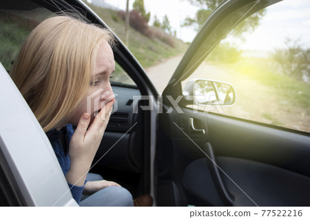 Nausea during a car trip. A blonde woman suffers from kinetosis. The concept of motion sickness in diseases of the transport and vestibular apparatus Nausea during a car trip. A blonde woman suffers from kinetosis. The concept of motion sickness in diseases of the transport and vestibular apparatus 77522216