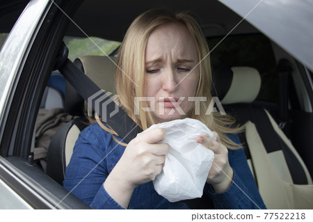 Nausea during a car trip. A blonde woman suffers from kinetosis. The concept of motion sickness in diseases of the transport and vestibular apparatus Nausea during a car trip. A blonde woman suffers from kinetosis. The concept of motion sickness in diseases of the transport and vestibular apparatus 77522218