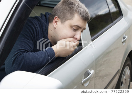 A ride during a car trip. The driver suffers from kinetosis, motion sickness. The concept of motion sickness in transport and vestibular apparatus disease A ride during a car trip. The driver suffers from kinetosis, motion sickness. The concept of motion sickness in transport and vestibular apparatus disease 77522269