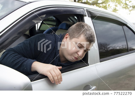 A ride during a car trip. The driver suffers from kinetosis, motion sickness. The concept of motion sickness in transport and vestibular apparatus disease A ride during a car trip. The driver suffers from kinetosis, motion sickness. The concept of motion sickness in transport and vestibular apparatus disease 77522270