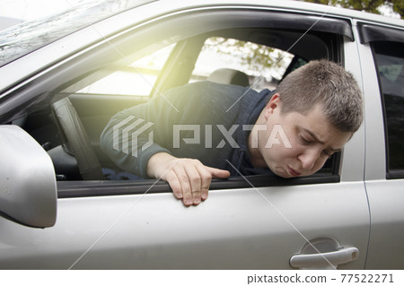 A ride during a car trip. The driver suffers from kinetosis, motion sickness. The concept of motion sickness in transport and vestibular apparatus disease A ride during a car trip. The driver suffers from kinetosis, motion sickness. The concept of motion sickness in transport and vestibular apparatus disease 77522271