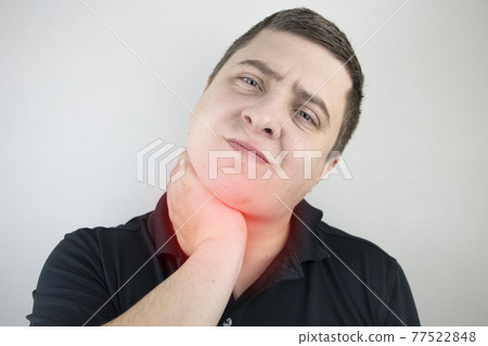 A man touches a sore throat and neck, twists from irritation and inflammation. Sore throat when swallowing, suspected pharyngitis or acid reflux. A man touches a sore throat and neck, twists from irritation and inflammation. Sore throat when swallowing, suspected pharyngitis or acid reflux. 77522848