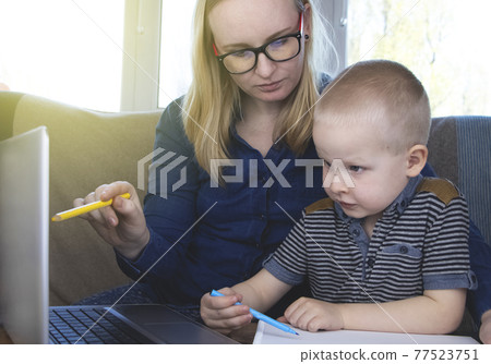 Mom and son do their homework, study online on the Internet. The concept of preschool education, home schooling of quarantined children during the coronovirus pandemic, covid-19 77523751