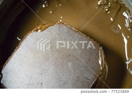 Melted chocolate in a pan under a water bath. Making hot chocolate at home in your own kitchen Melted chocolate in a pan under a water bath. Making hot chocolate at home in your own kitchen 77523889