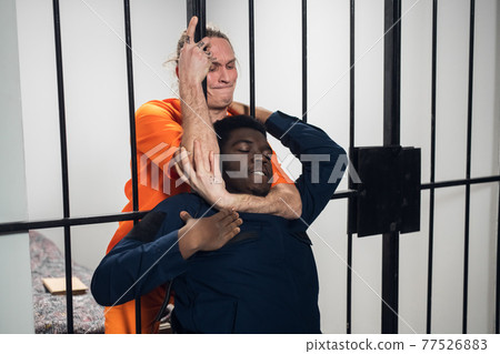 A dangerous maniac attacks a black warden from his solitary cell in order to escape. A dangerous maniac attacks a black warden from his solitary cell in order to escape. 77526883