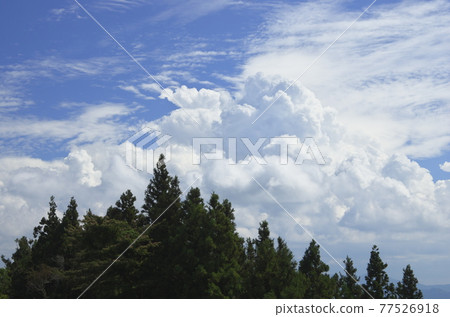 A big cloud springs up in the blue sky 77526918