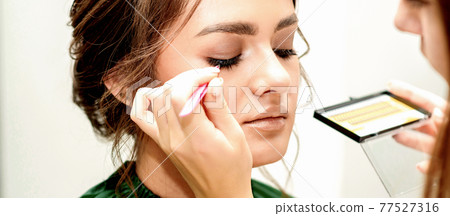 Young woman receiving eyelash extensions Young woman receiving eyelash extensions 77527316