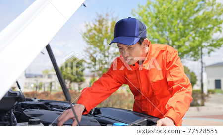A male auto mechanic who opens the hood of a car A male auto mechanic who opens the hood of a car 77528535