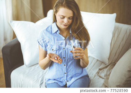 Close-up woman holding pills time to take medications, cure for headache, high blood pressure or cholesterol level remedy pain killer drugs. Medicine concept 77528590