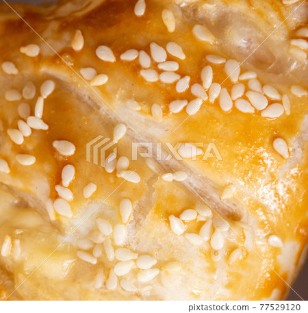 Yeast dough puff with sesame seeds, close-up. Delicious pastries 77529120