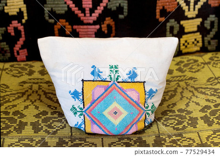 Rustic pillow with an embroidered pattern and ornament, traditional, close-up. Rustic pillow with an embroidered pattern and ornament, traditional, close-up. 77529434