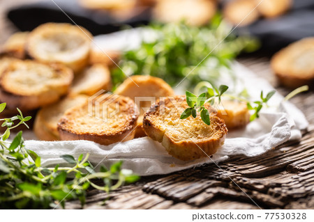 Small round mini bake rolls with lovely crunchy flavour and goldish colour made of baked bread and served in the paper or dish cloth with thyme Small round mini bake rolls with lovely crunchy flavour and goldish colour made of baked bread and served in the paper or dish cloth with thyme 77530328