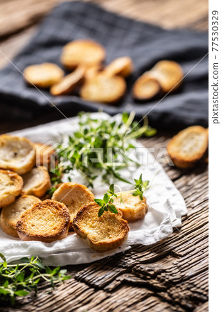 Small round mini bake rolls with lovely crunchy flavour and goldish colour made of baked bread and served in the paper or dish cloth with thyme Small round mini bake rolls with lovely crunchy flavour and goldish colour made of baked bread and served in the paper or dish cloth with thyme 77530329