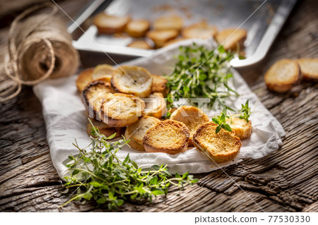 Crispy goldish bake rolls with savory flavour, served with lovely green thyme tied by flax twine Crispy goldish bake rolls with savory flavour, served with lovely green thyme tied by flax twine 77530330