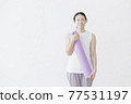 Woman fitness beauty with a yoga mat on the back of a white wall 77531197