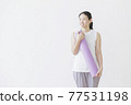 Woman fitness beauty with a yoga mat on the back of a white wall 77531198