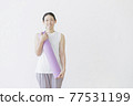 Woman fitness beauty with a yoga mat on the back of a white wall 77531199