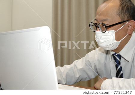 Middle-aged man working from home 77531347