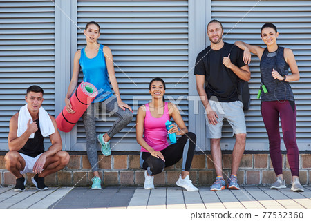 Happy mixed race youth holding sport equipment 77532360
