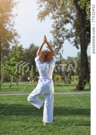 Little girl in white kimono meditating on the street 77532452