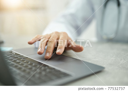 Male doctor hand using modern laptop in clinic Male doctor hand using modern laptop in clinic 77532737