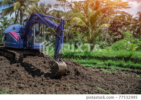 industrial bulldozer excavate ground and soil in tropical rain forest 77532995