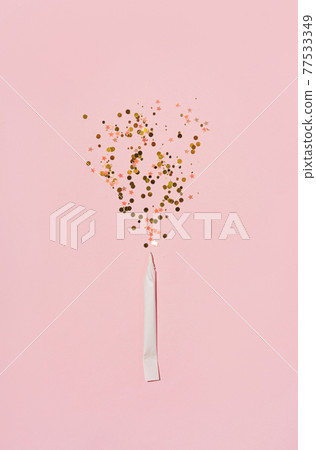 Explosion of sparkles from hahd rolled paper cigarette, on pastel pink background. flat lay Explosion of sparkles from hahd rolled paper cigarette, on pastel pink background. flat lay 77533349