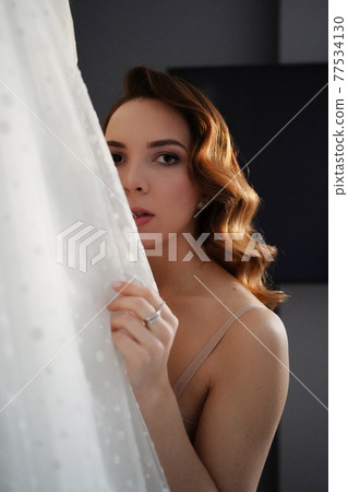 bride with long hair in underwear next to a white wedding dress bride with long hair in underwear next to a white wedding dress 77534130