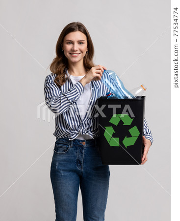 Plastic Reuse. Positive Millennial Lady Carrying Black Container Filled With Empty Bottles Plastic Reuse. Positive Millennial Lady Carrying Black Container Filled With Empty Bottles 77534774