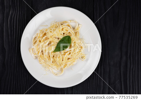 Pasta with sauce and basil 77535269