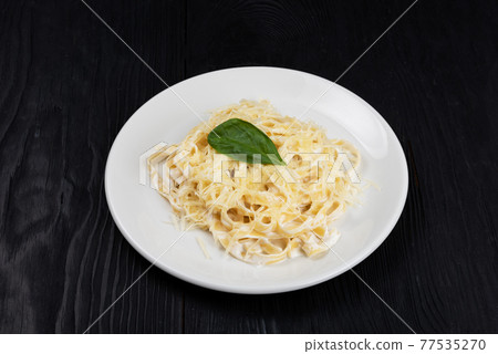 Pasta with sauce and basil 77535270