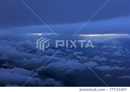 Clouds in dark sky and horizon line 77535997