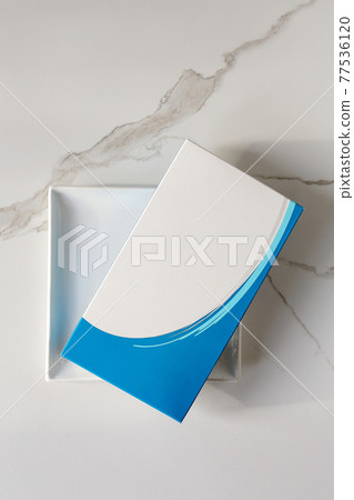Paper box with Syringe with needle and vial, Covid-19 vaccines. Pharmaceutical corporation Pfizer with BioNTech devoleped a vaccine on Covid-19. 77536120