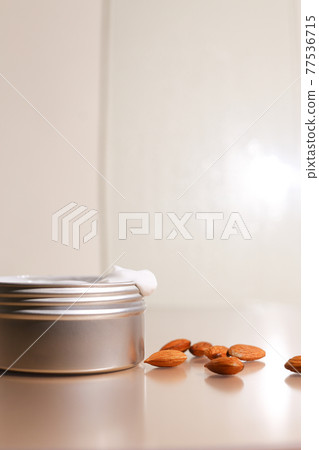 Aluminum round jar for cosmetics with almonds. Metalic cosmetic bottles. Blank mock up advertising container with copy space. Aluminum round jar for cosmetics with almonds. Metalic cosmetic bottles. Blank mock up advertising container with copy space. 77536715