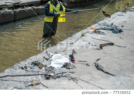 volunteer cleaning small industrial city river from garbage and dangerous waste volunteer cleaning small industrial city river from garbage and dangerous waste 77538932